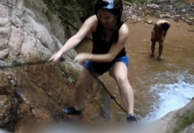 Mulher tenta escalar cachoeira