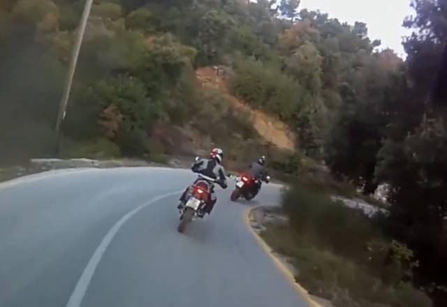 Motos fazem curvas em estrada